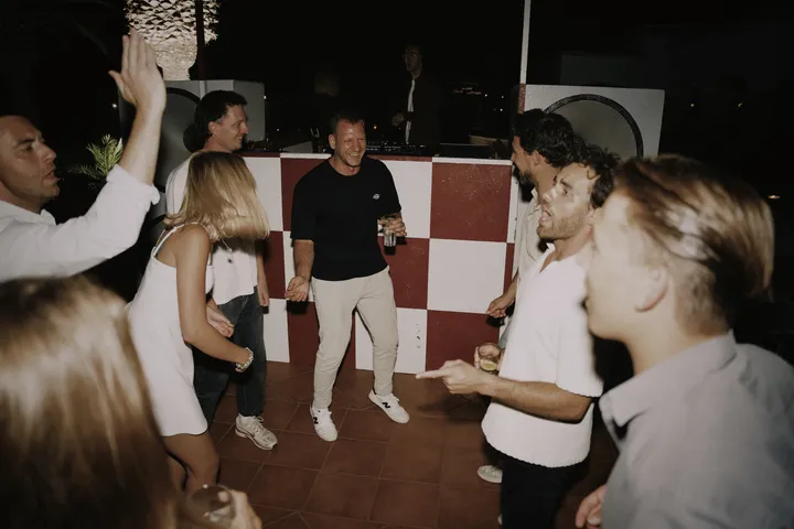 Gäste feiern ausgelassen vor dem DJ-Pult