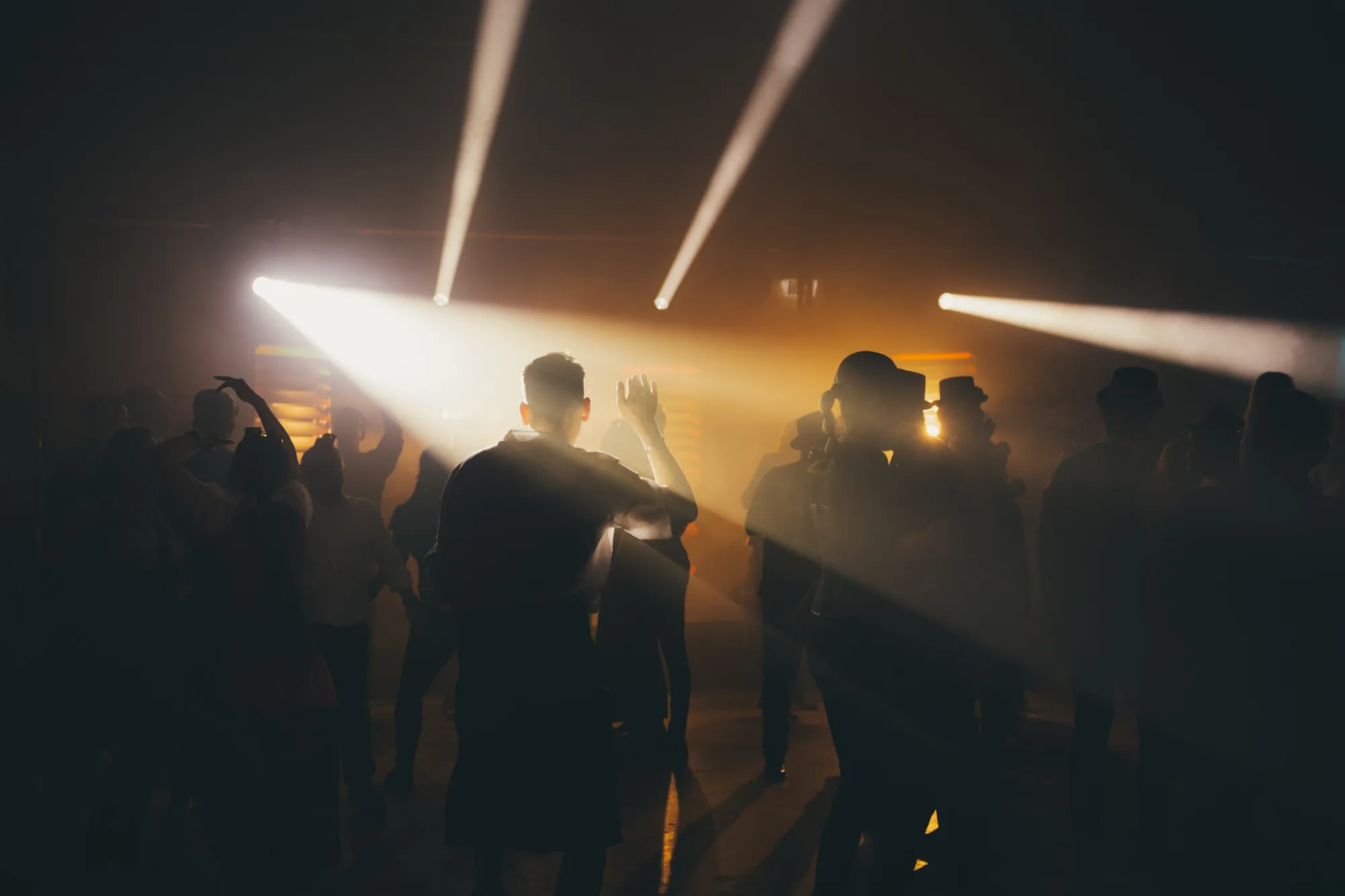 Kolleginnen und Kollegen tanzen unter Lichtstrahlen