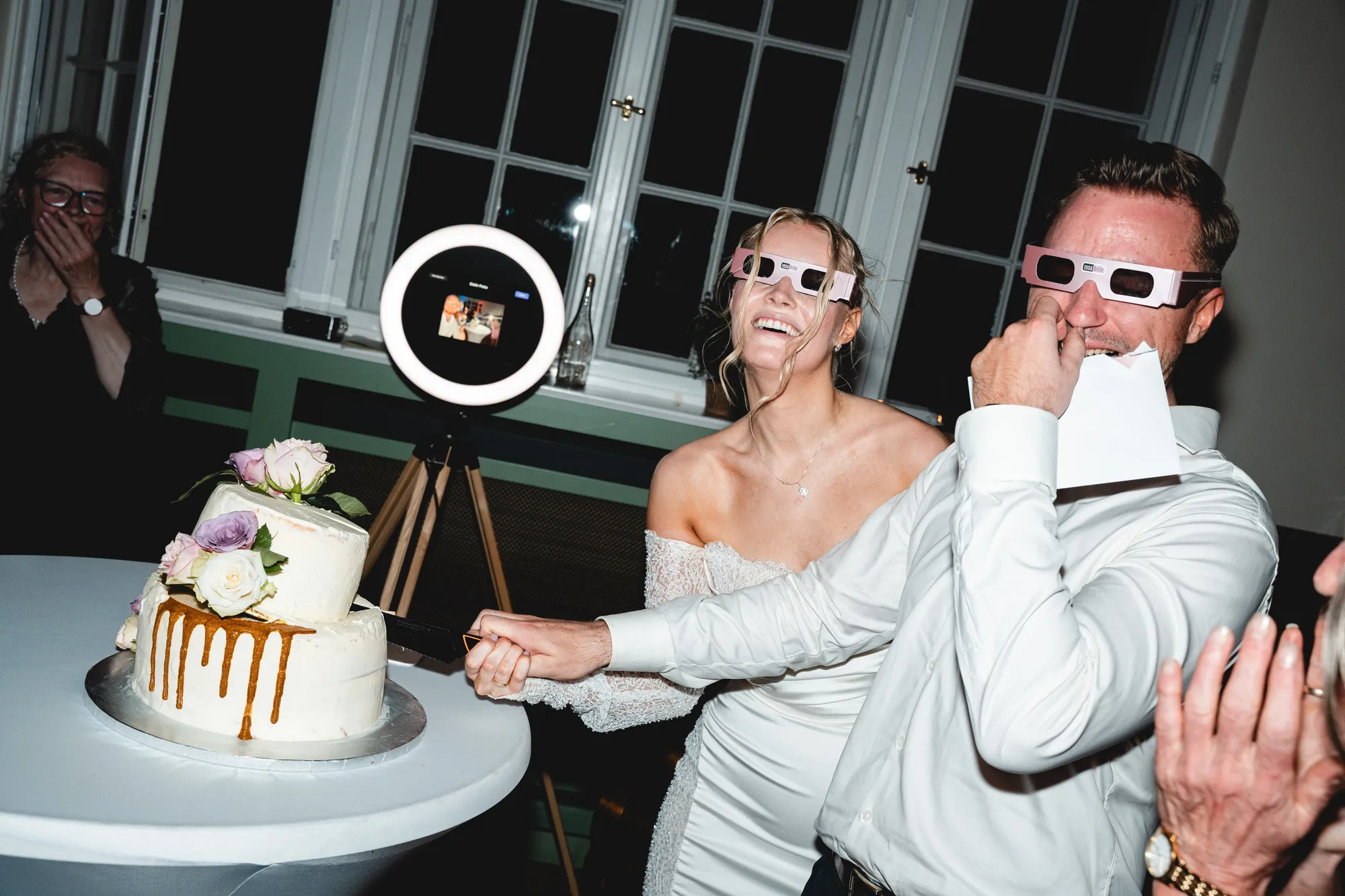 Gäste mit Partybrillen posieren vor der Fotobox mit Ringlicht