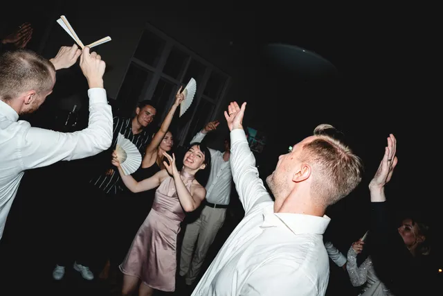 Gäste mit weißen Fächern auf der Tanzfläche