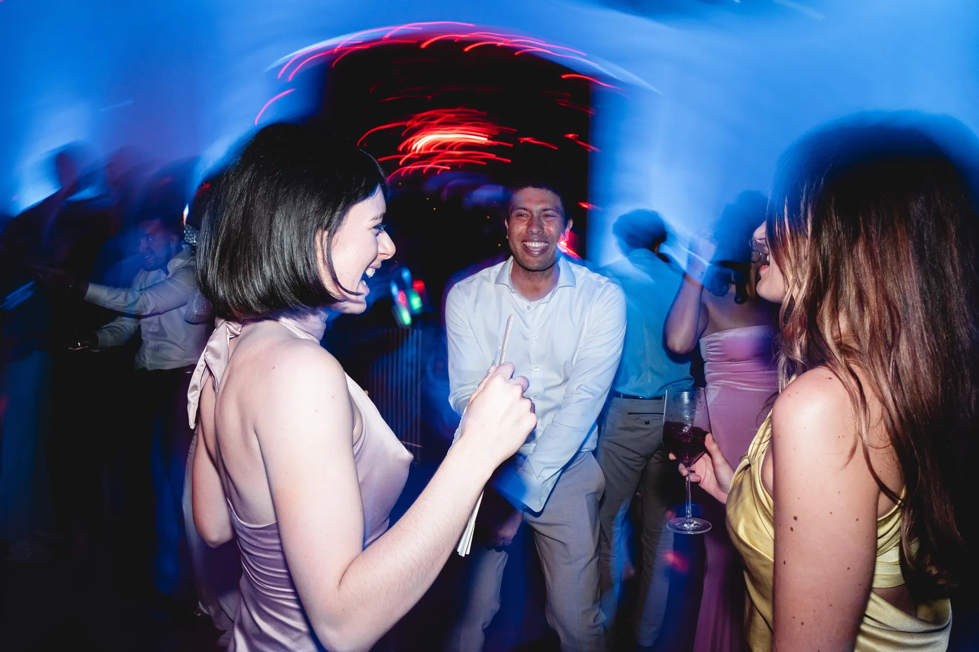 Hochzeitsgäste tanzen im blauen und roten Partylicht